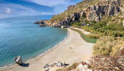 Stunning Preveli Beach, a secluded white sand beach surrounded by palm groves at the end of a gorge where the Megas river encounters the Libyan sea, Crete, Greece