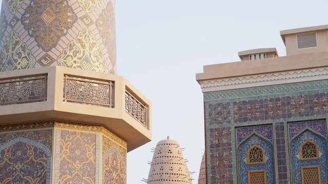 Blue mosque of Katara village made of colorful mosaic in Doha Qatar showing Pigeon tower behind
