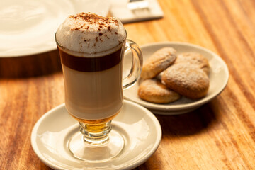 Taza de café capuchino con galletas