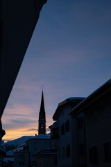 Idyllisches Bergdorf im letzten Sonnenlicht im Winter, Kirchturm S-chanf