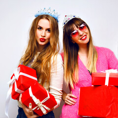 Funny indoor portrait of two happy pretty girls having fun masquerade  party,