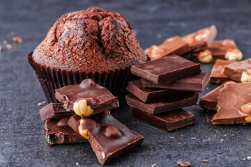 Chocolate cupcake with icing and chocolate bar in Dark lighting,Homemade delicious chocolate muffin...