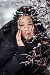 Portrait of a woman near a branch. Winter photo session - 475377795