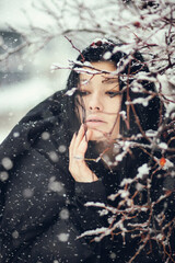 Portrait of a woman near a branch. Winter photo session - 475377796