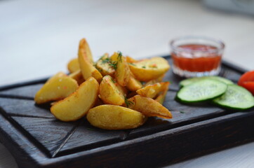 Potatoes country style with spices on the wooden plate