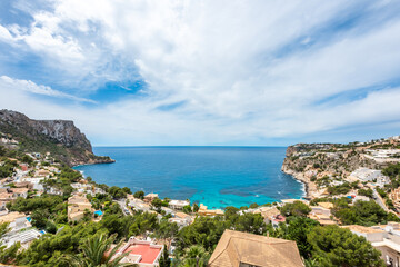 View of the coast of Cala Llamp in Mallorca, sky and blue sea between houses