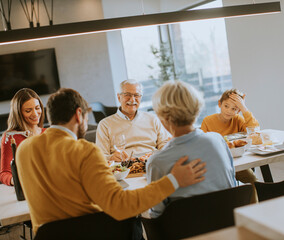 Happy family having a dinner with red wine at home