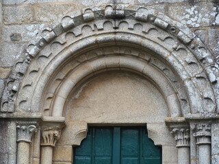 portada sur de la iglesia románica de santa maria de mellid, dos arquivoltas semicirculares, guardapolvos con círculos y tacos, arquillos, un tímpano desgastado, la coruña, galicia, españa, europa   