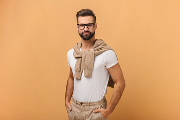 Portrait of happy smiley handsome bearded man wearing white t shirt posing against orange background. Studio shot. Stock photo