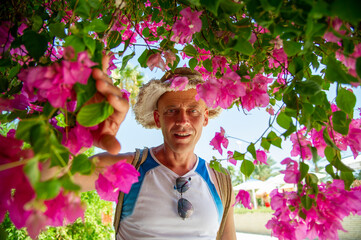 Fototapeta na wymiar Portrait man 50 years old with pink flowers