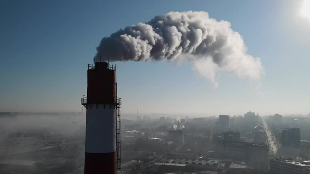Aerial drone view of industrial smoke coming from pipe factory tube. City pollution idea