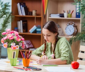 Young girl drawing pictures at home