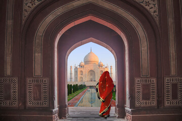 India, Agra, Taj Mahal. Composite of woman in archway facing mausoleum.