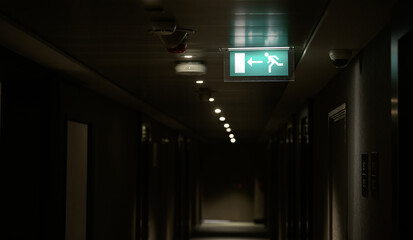 Exit sign inside a hotel hallway. This indicators show to tourists the direction they have to go in...