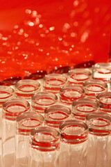A lot of empty clean glasses used for water and juice are placed on a table and are ready to be served.