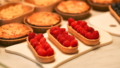 Some cakes raspberry of blueberry in the window of a pastry bakery store.