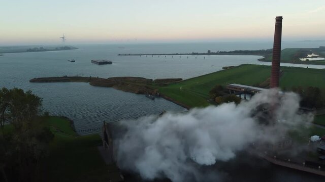 Steam rising up from the ir. D.F. Woudagemaal Steam Pumping Station in Lemmer during sunrise. Drone view