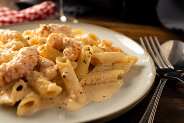 closeup of a dry penne rigate pasta with a delicious shrimp and prawn cream.