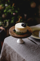 Beautiful bento cake with blackberries and rosemary on a wooden stand. Christmas cake on the table