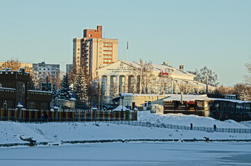 winter. View of the building with columns and a multi-storey house