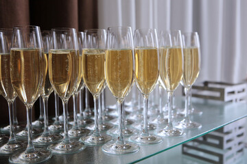 A secular reception. Champagne glasses on the table. Buffet at a social party. Lots of wine glasses. A gala dinner or an event. Alcoholic beverage.