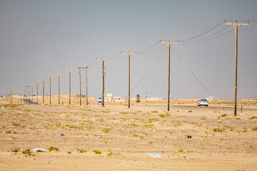 Middle East, Arabian Peninsula, Al Batinah South, Mahout. A power line and road in the desert of...