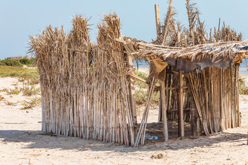 Middle East, Arabian Peninsula, Al Batinah South, Mahout. A sun shelter made from reeds on the beach in Oman.
