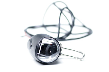 Bicycle headlight with mirrored lens. The flashlight for the electric bike lies on a white...