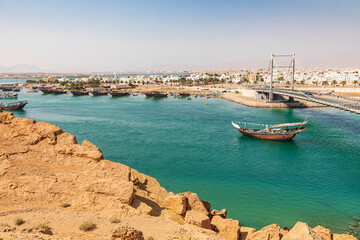 Middle East, Arabian Peninsula, Oman, Al Batinah South. Dhow passing under a suspension bridge.