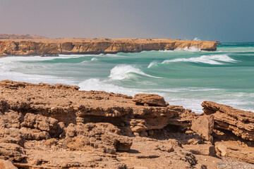 Middle East, Arabian Peninsula, Oman, Al Batinah South. Breaking surf along the rugged coast of the...