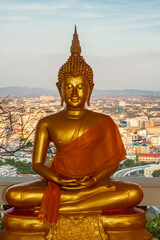 Asia, Thailand, Pattaya. Buddha statue with city in background.