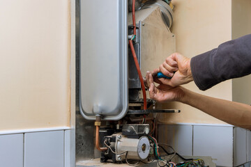 Repairman fixing a gas water heater with repair service