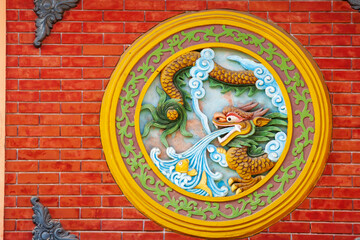 Vietnam, Hoi An. Colorful dragon relief on side of building.