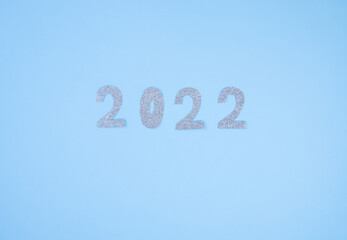 Naklejka premium Happy New Year 2022. Christmas background with silver glittering numbers 2022 on light blue background. View from above. Place for your text.
