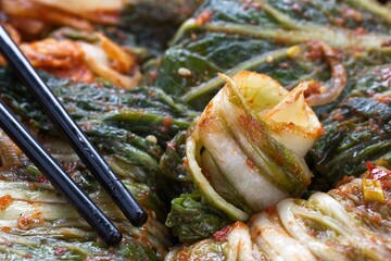 Still life close up of kimchi and chopsticks.