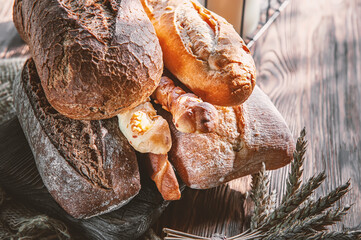 Assorted bread products on a wooden table. variety of wheat and rye bread are presented on a wooden relief background.