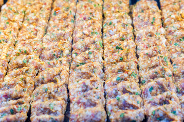 Cooking raw pork kofta marinated in spices on a skewer