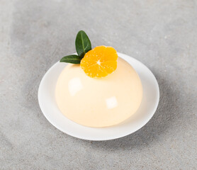 Creamy Tangerine pudding on a platte on a light gray background. Top view
