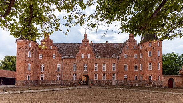 the danish Holsteinborg Castle and courtyard under green beech branches