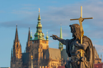 Fototapeta na wymiar Statue of St. John the Baptist on the Charles Bridge with the Prague Castle and St. Vitus Cathedral the background, Prague, Capital city of Czech, UNESCO World Heritage Site, Czech Republic