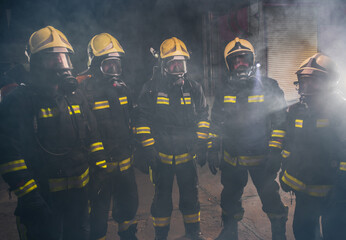Portrait of group of firefighters in the middle of the smoke of the fire extinguisher