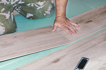 Laying laminate flooring with your own hands. The master lays the laminate coating on the concrete floor. Home renovation with your own hands. DIY home