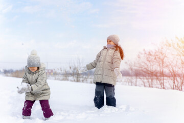 Happy children play snowballs, run, throw snow. Funny kids play games indoors in the winter with...