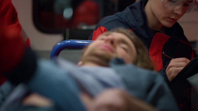 MS paramedics giving ambulance help to patient in emergency vehicle