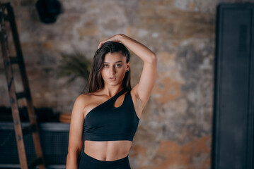 Fototapeta na wymiar Sportive woman in sportswear posing at the camera. Sport and gym concept