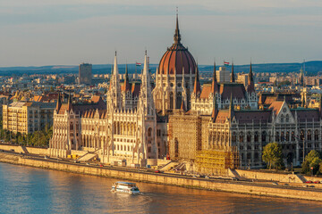 Fototapeta premium Tour boat passes Hungary's Parliament, built between 1884-1902 is the country's largest building. It has 691 rooms and sits next to the Danube River, Budapest, Hungary.