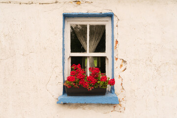 Fototapeta na wymiar Europe, Ireland, Cashel. House with colorful window and flowers.