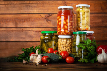 canned and fresh vegetables on wooden background