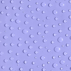 Water drops on purple background. Water texture close up. Backdrop glass covered with drops of water. Water bubbles. Trendy banner with 2022 color of the year very peri.