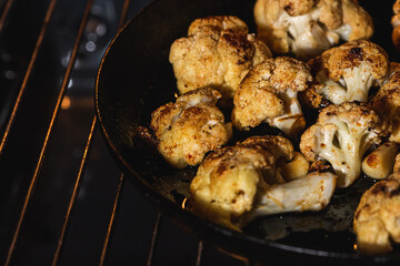 Cooking, fried cauliflower with herbs and spices. Vegetarian food, healthy food baked in the oven. Selective focus. Low key